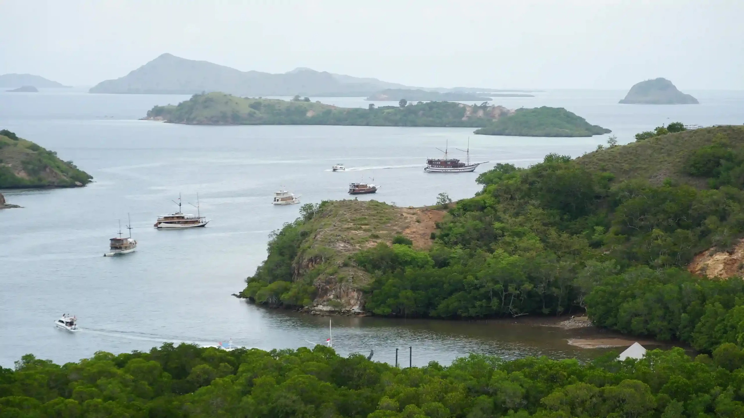 A boat at the jetty below the dry hills of Rinca Island in Komodo National Park