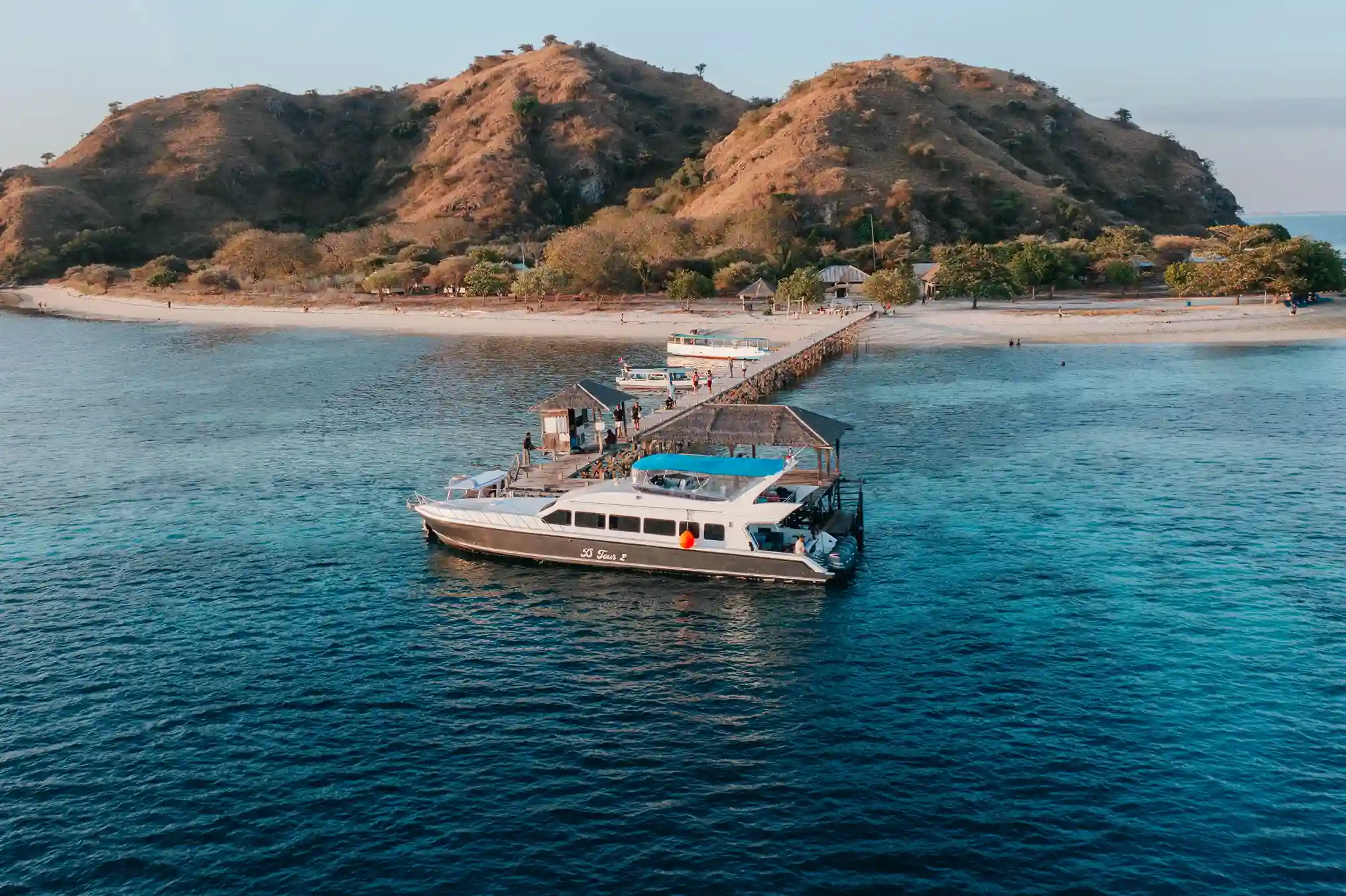 A speedboat moored off the white sand of Kanawa Island