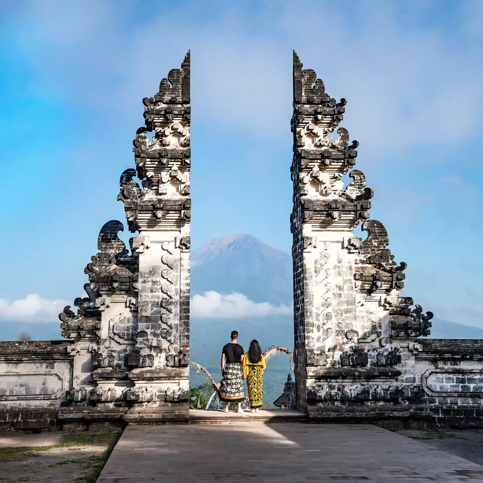 Visitors in temple dress framed by the split gate at Pura Lempuyang Luhur