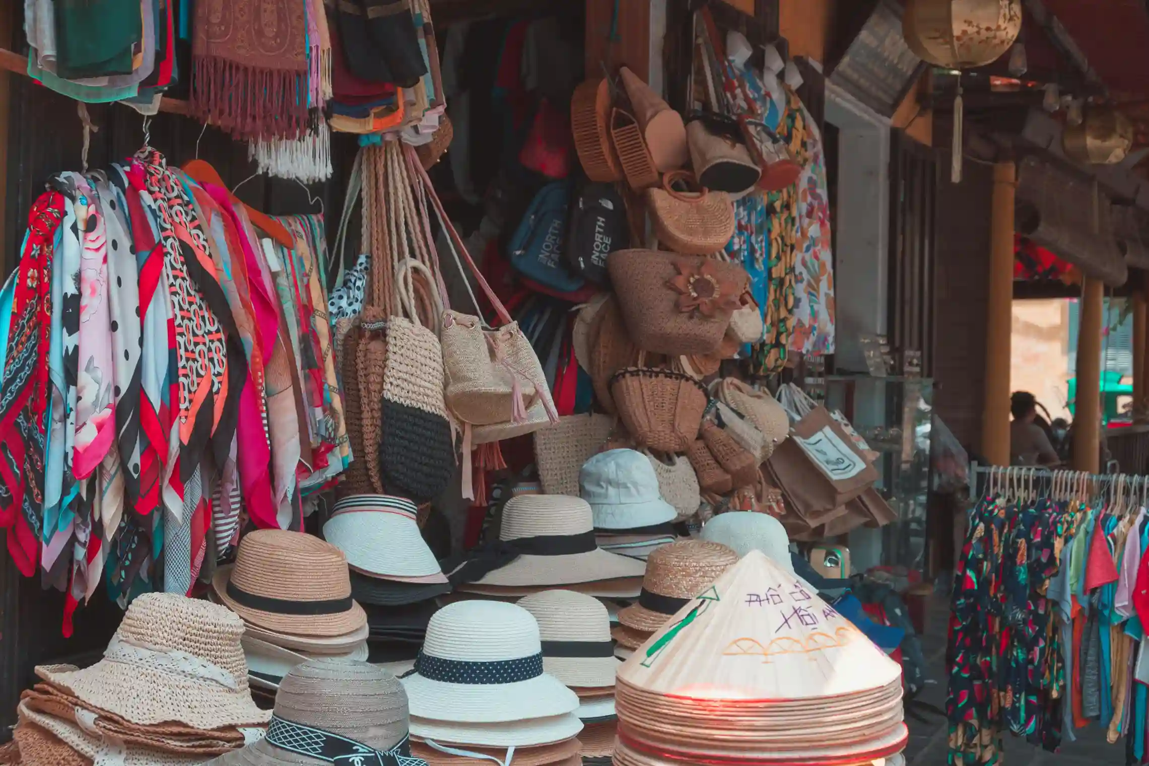 Hats, bags and textiles stacked on the stalls of Ubud art market